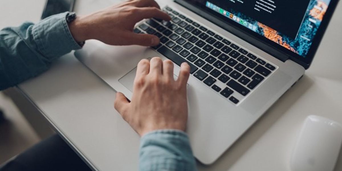 person wearing long-sleeve top working on laptop