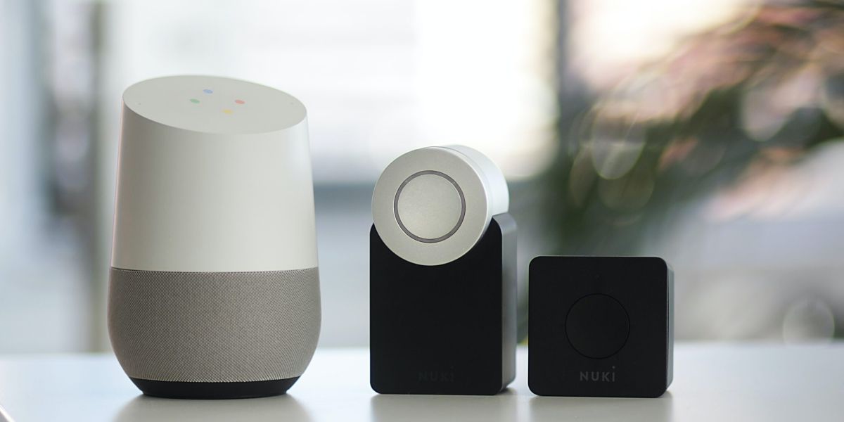 white and gray Google smart speaker and two black speakers